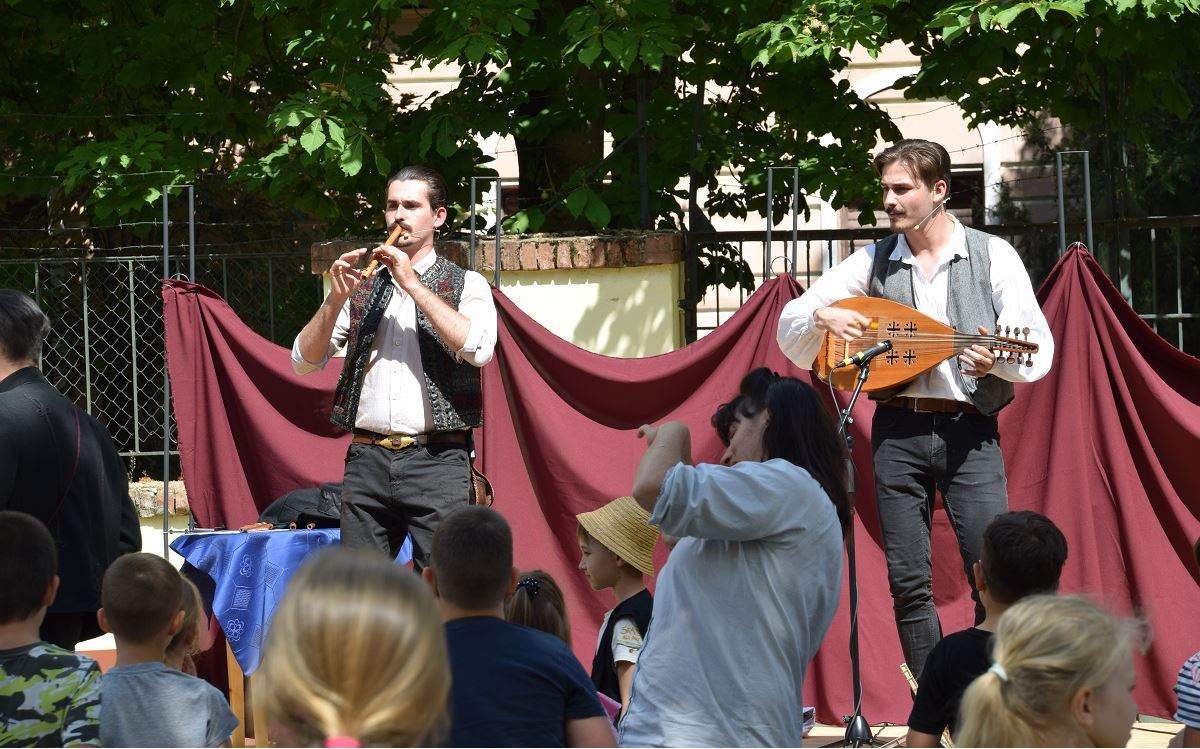 KACKIÁS FOLKSZÍNHÁZ: MÁRCIUSI MESE Interaktív táncos-zenés mesejáték Nemzeti ünnepünkhöz, március 15-höz kapcsolódó műsorban Móra Ferenc meséiből válogattak a Kackiás FolkSzínház mesélői. A gyerekek aktív bevonásával, gyönyörű muzsikával, ízes mesemondással a Dióbél Királyfi meséből elevenedik majd meg Kossuth Lajos alakja, amikor a vidékünkre látogatott, valamint a Vak Csiha furulyájának érdekes történetével is megismerkedhetnek a családok. A Kackiás FolkSzínház célja, hogy előadásaik során megtörjék a képzeletbeli falat az előadó és néző között, miközben interaktívan, zenés-táncos elemekkel és élő zenével szórakoztatják a nagyérdeműt. Előadják: Gombás Bende, Keserű Benedek Belépődíj: 500 Ft
