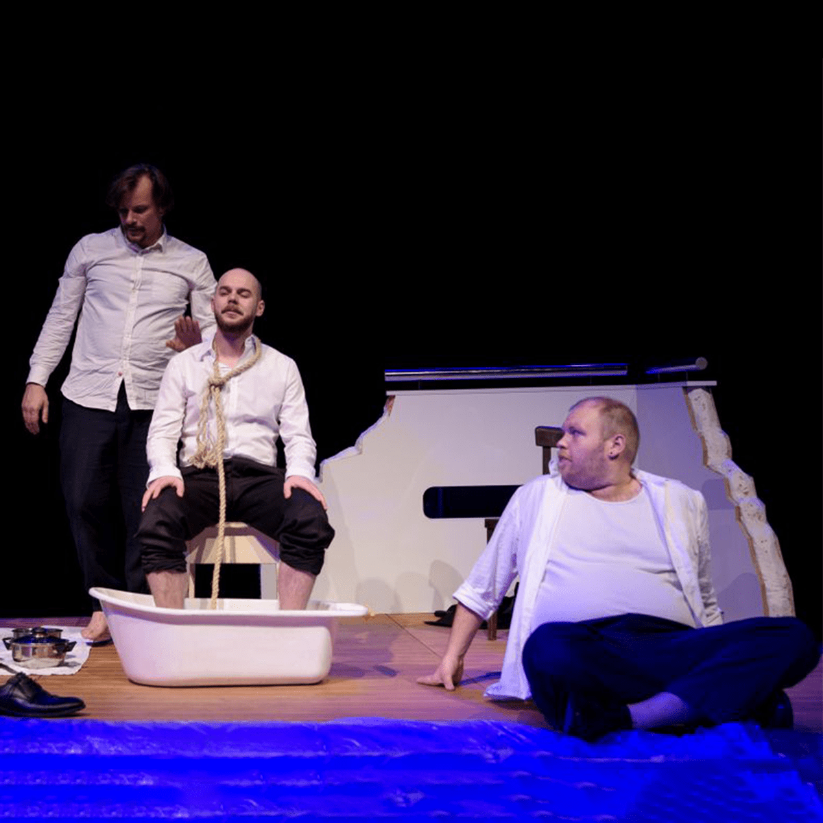 Mrožek: A nyílt tengeren Három ember egy tutajon. Vészhelyzet, amely leleplezi az emberi természet valódi arcát. Mrozek abszurd drámája azt vizsgálja, hogy amikor az élet és halál közötti választásra kényszerülünk, milyen mértékű emberségünk marad meg – és ezt a nem-emberséget nevezhetjük-e még méltóságnak? A katasztrófa azonban nem csak szörnyűségeket tár fel: az abszurdban rejlő tragikomikum lehetőséget ad arra, hogy önmagunkra és társadalmunkra másként tekinthessünk. A darab egy fundamentális kérdést tesz fel: működhet-e az egyenlőség, a demokrácia, az igazság egy olyan világban, ahol az alapvető erőviszonyok teljesen aszimmetrikusak? A válasz nem vigasztaló. A hatalom nem néz a szemünkbe – nem is kell, mert elég egy gesztus, egy szavazat, egy ígéret, hogy az ember megtörjön és megadja magát. Mégsem ez a pesszimizmus az utolsó szó. Valamiképpen a legyőzöttség közepén a valódi szabadság lehetősége rezdül meg, amit a belső tudatosság vezérel – és ezáltal a minden feladása is lehet felemelő tett. A darab humora és könnyedsége azonban megenyhíti ezt az értelmezést: csak akkor szabadulhatunk meg, ha képesek vagyunk magunkra és helyzeteinkre gúnnyal, öniróniával tekinteni. Ha az ember vállalja a sorsát, akkor már nem fogoly többé, hanem szabad – és talán még nevetni is tud rajta. Alkotók: Konfár Erik - A Kövér Bárnai Péter - A Középső Varga Levente - A Kicsi Sárosi Gábor - Postás Keller Dániel - Lakáj/Hegedűs Dramaturg: Sárosi Gábor Szinháztechnikus: Barcsik László/Bujdosó Zsolt Díszlettervező: Nagy János/Pesti Mátyás Asszisztens: Pethő Laura Rendező: Nagy János